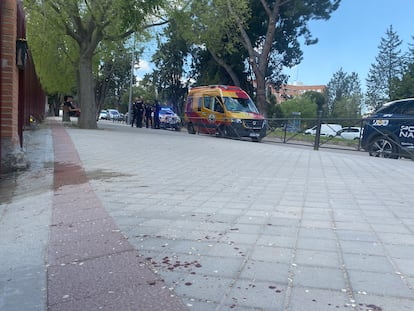 La puerta del colegio en el que la víctima ha pedido ayuda, al fondo, la ambulancia que lo ha atendido.