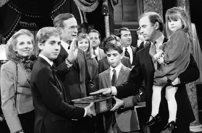 Joe Biden (a la derecha), con su hija Ashley en brazos, durante el ensayo de juramento frente al vicepresidente George Bush, en el Capitolio de Washington cuando era miembro del Senado, en 1985.