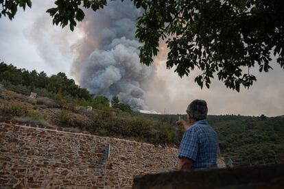 Teodomira Martín (85), de Carabusino, observa la columna de humo desde la acera de su casa a primera hora de la mañana. Al mediodía, el dispositivo de seguridad se había ampliado hacia esta alquería, pudiendo ser desalojada si el fuego continúa expandiéndose.