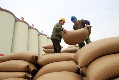 Trabajadores chinos descargan sacos de soja importada en el puerto de Nantong, al este de China.