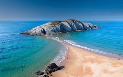 En bajamar es una preciosa línea de arena que permite tocar el islote de El Castro; en pleamar, como si de un espejismo se tratase, todo es un Cantábrico salvaje que asedia esa pequeña porción de tierra. A este paraíso naturista al oeste de la ciudad de Santander acude un público mayoritariamente joven, amantes de los paseos o parejas con ganas de vivir un día de espaldas al ruido urbano. Pero el salvajismo se manifiesta también en el acceso, afectado por los temporales, con lo que habrá que hacer equilibrios en la bajada. La entrada al mar es progresiva. Quienes acaricien la posibilidad de encaramarse al islote de El Castro —territorio de pescadores— deberían informarse y memorizar bien el horario de mareas y así no tener que ser rescatados con cuerdas por los socorristas de la playa.