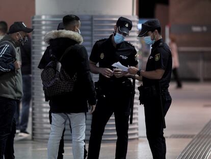 Agentes de la Policía Nacional revisan la documentación de varios pasajeros en la Estación de Atocha, en Madrid, el lunes.