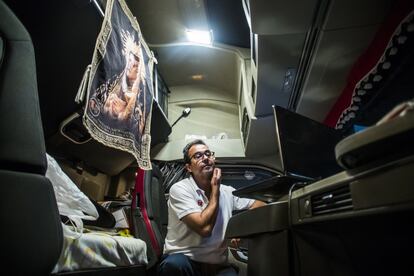 Lázaro Bermejo, camionero murciano de la empresa Hermanos Fuentes, de noche, viendo una serie en su portátil, en una estación de servicio en Huntingdon, Reino Unido, donde va a descargar el camión lleno de uvas, el 14 de octubre de 2021.