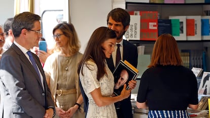 La reina Letizia, en una de las casetas de la Feria del Libro de Madrid, este viernes. Detrás, el ministro de Cultura, Ernest Urtasun.