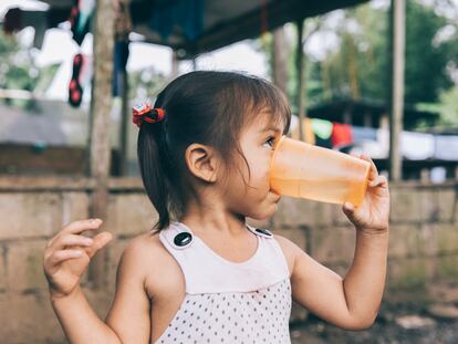 Una niña bebe agua potabilizada en San Fernando de Orellana, Ecuador.