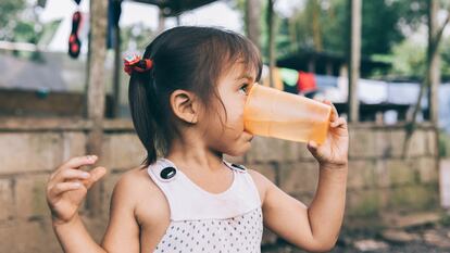 Una niña bebe agua potabilizada en San Fernando de Orellana, Ecuador.