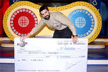 Rafael Moreno Gómez sostiene un cheque simbólico con los 72 millones de pesetas del premio.