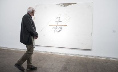 Un participante en la celebración de los 25 años de la Fundación observa una obra de Tàpies.