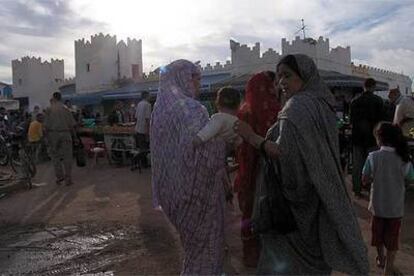 Mujeres en el zoco viejo de Sidi Ifni, con las murallas al fondo.