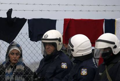 Una mujer mira a policías griegos en la frontera con Macedonia, en una foto de archivo.