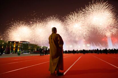 Un monje de budista observa los fuegos artificiales durante la ceremonia de la apertura de la exposición Universal de Shanghai