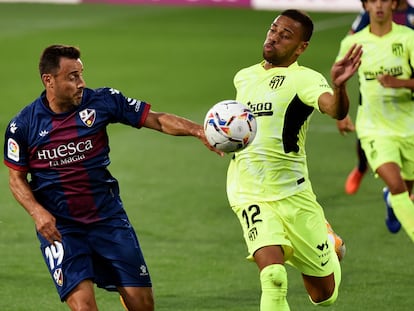 El defensa brasileño del Atlético de Madrid Renan Lodi pelea por el control del balón con el jugador de la SD Huesca, Pedro López, durante el partido de la cuarta jornada de Liga en Primera División que disputan este miércoles en el estadio El Alcoraz.