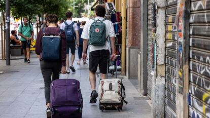 Turistas con sus maletas en el centro de Valencia.