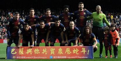 Los jugadores del Barcelona posan con niños y un cartel en chino antes del duelo con el Getafe.