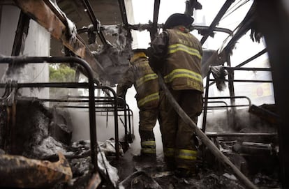 Restos de un autobús, incendiados por los presuntos narcos durante el tiroteo.