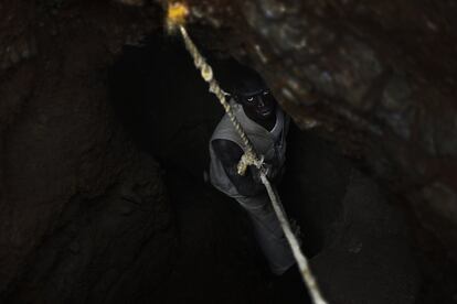 Comuna de Kaya. Mina de Koutoula Yarcé. Un minero ata su cuerpo a una soga en mal estado como única medida de seguridad.  Los recursos y las herramientas son rudimentarias en la mayoría de casos. En ocasiones las manos y poco mas. Algunos consiguen liderar un grupo de trabajadores y compran herramientas que prestan a cambio de una parte del beneficio obtenido en la mina o de un alquiler.