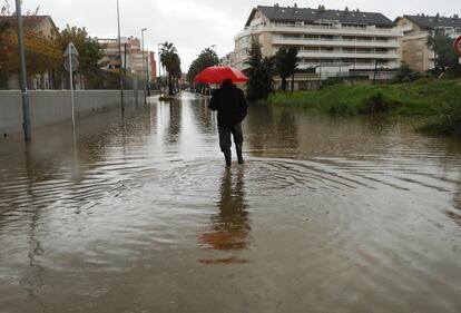 Un hombre pasea por una calle anegada este lunes en Dènia (Alicante).
