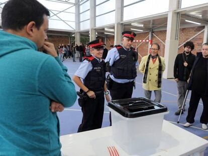 Una parella dels  Mossos d'Esquadra, davant una urna durant la jornada de l'1-O.