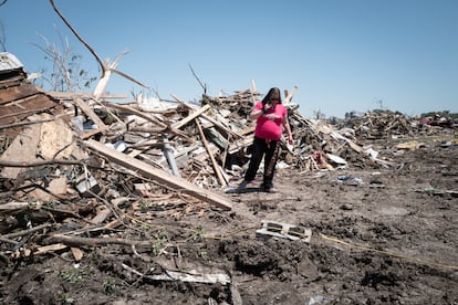 Victoria Turner camina entre los escombros de su hogar. Turner sobrevivió gracias a que se refugió en el sótano durante el paso de los tornados, en Greenfield, Iowa. El servicio de electricidad se ha visto muy afectado. Este martes hasta un millón de hogares, principalmente en Texas, estaban sin luz. 