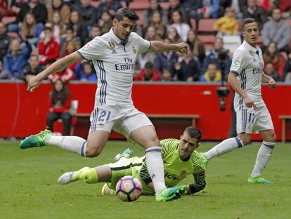 El delantero del Real Madrid Álvaro Morata (i) supera al portero del Sporting, Iván Cuéllar 'Pichu' (c) ante su compañero Lucas Vázquez (i).