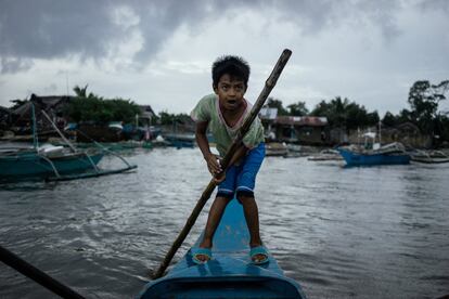 Un niño conduce un barco de pescadores en una aldea del municipio de Taytay. El 70% de la población de esta demarcación vive de la pesca. 

