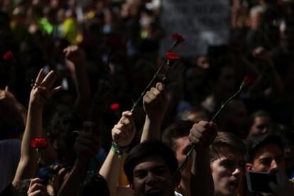 Varios manifestantes sostienen claveles durante una protesta frente al Tribunal Superior de Justicia de Cataluña, en Barcelona (España).