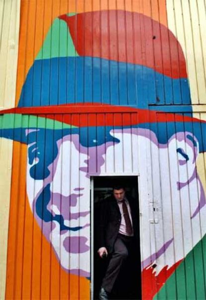 Un hombre sale de un garaje bonaerense decorado con un retrato de Gardel.