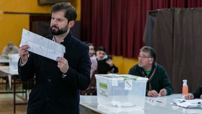 El presidente de Chile, Gabriel Boric, muestra su planilla de votación a los periodistas que registraron su voto.
