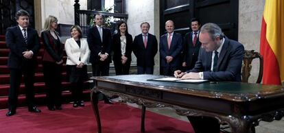 El presidente de la Generalitat firma el decreto de disolución de las Cortes delante de su Gobierno.