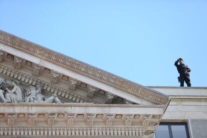 Un miembro de la policía vigila desde la azotea del Congreso.