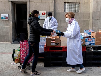 Una mujer recibe alimentos de una fundación, en Madrid. EP