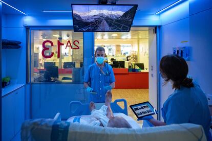 Cristian Lucas, fisioterapeuta, y Patricia del Barrio, terapeuta ocupacional, atienden a un paciente en las nuevas UCI mulisensoriales del hospital de Bellvitge en Hospitalet de Llobregat (Barcelona).