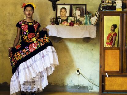 Retrato de Kazandra vestida con el traje tradicional del Istmo de Tehuantepec junto al altar familiar. En todas las casas zapotecas se puede encontrar uno dedicado 
a los seres queridos fallecidos, con sus retratos  y estampas de santos.