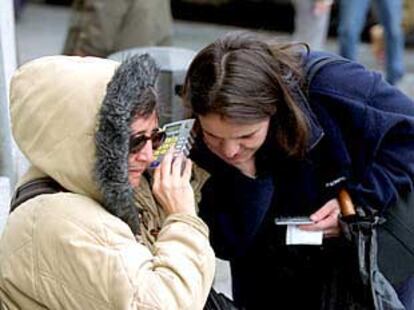 Una mujer calcula un precio con un conversor que le dice el resultado de viva voz, ayer, en la Puerta del Sol en Madrid.