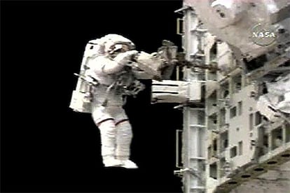 Piers Sellers, con rayas rojas en las perneras del traje como distintivo, durante el paseo espacial de ayer.