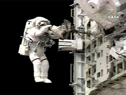 Piers Sellers, con rayas rojas en las perneras del traje como distintivo, durante el paseo espacial de ayer.