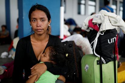 Marlioth Armas, de 28 anos, segura a filha Erimar, de 2, enquanto espera em uma fila para processar seus documentos no centro de serviço fronteiriço entre o Equador e o Peru, antes de continuar sua viagem a Lima. Marlioth chora de frustração ao lembrar da escassez de bens básicos pela qual emigrou da Venezuela: "Só quero viver em um local onde possamos obter coisas e ser normais".