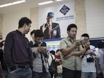 Vários clientes revisam seus celulares em um supermercado de Tianjin (China), em 28 de setembro.