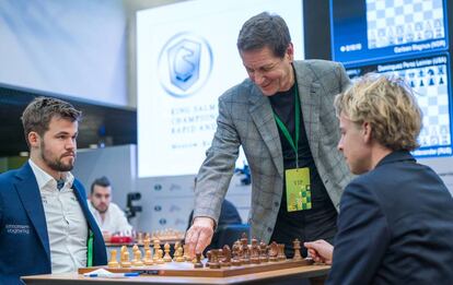 Carlsen mira al checo Laznicka mientras Alexánder Zhúkov, presidente adjunto del Parlamento de Rusia hace el saque de honor