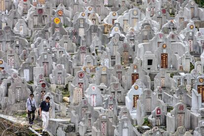 Una pareja visita las tumbas de familiares fallecidos, durante el Festival de Chung Yeung, conocido como el 'Día del barrido de tumbas', en un cementerio en Hong Kong.