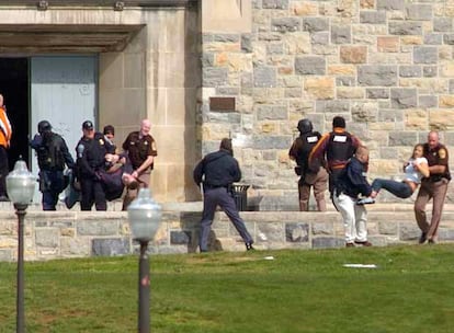 Varios policías van y vienen de la entrada de Norris Hall, en el campus de Blacksburg, transportando algunos heridos que se encontraban aún en el interior del edificio donde una persona ha disparado contra los estudiantes, en las clases tanto como en los dormitorios.