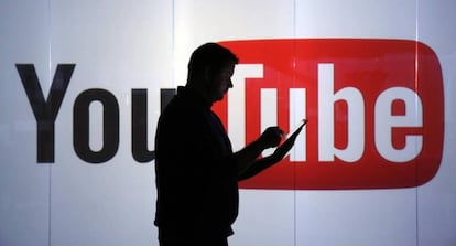 Un hombre junto al logo del portal de vídeos YouTube.