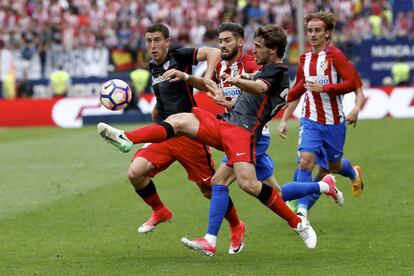 El jugador del Atlético de Madrid, Yannick Carrasco, lucha por hacerse con el balón ante Oscar de Marcos (izda,) y Yeray Álvarez, del Athletic de Bilbao.