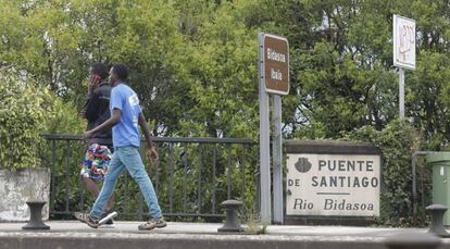 Dos extranjeros cruzan el puente de Santiago, en la frontera francoespañola en Irún (Gipuzkoa).