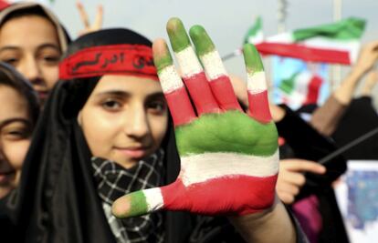 Una joven iraní muestra la palma de la mano con los colores de la bandera nacional durante un acto en conmemoración del 35 aniversario de la Revolución Islámica en 1979, en la plaza Azadi o Plaza de la Libertad en Teherán (Irán).