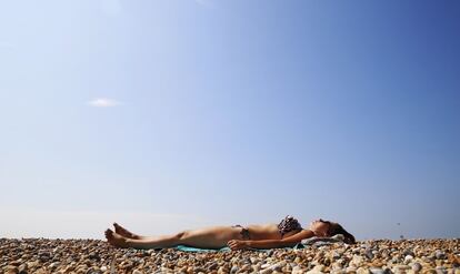 Una joven toma el sol en una playa de Brighton, Reino Unido. 23 de julio de 2014.