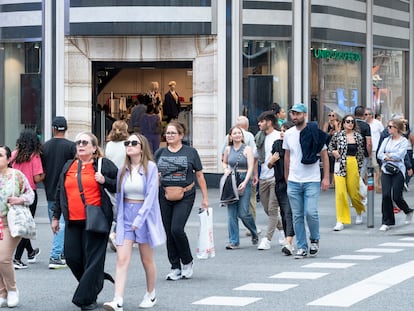 Una multitud pasea por la Calle Gran Vía, en el centro de Madrid.