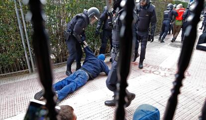 Agentes de la policía detienen a un manifestante.