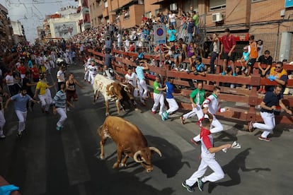 Unos mozos corren delante los toros en el primer encierro de San Sebastián de los Reyes.