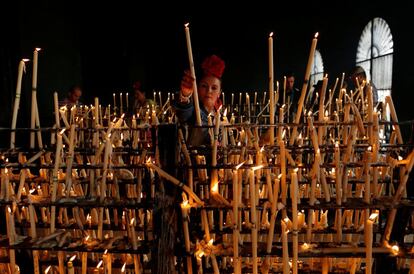 Una mujer enciende una vela durante la romería en la ermita de El Rocío, en Almonte.